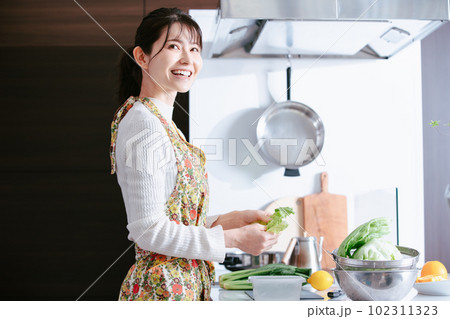 キッチンで料理する女性 102311323