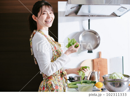 キッチンで料理する女性 102311333