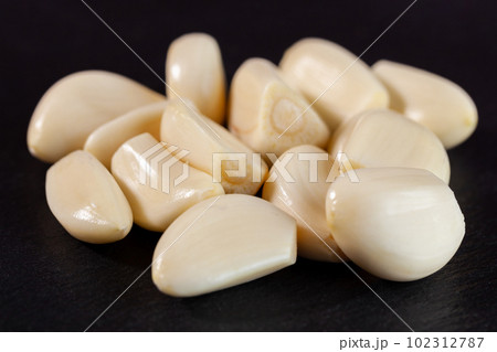 Garlic cloves. Raw garlic isolated on black background. Vegetable Garlic cloves. Raw garlic isolated on black background. Vegetable 102312787