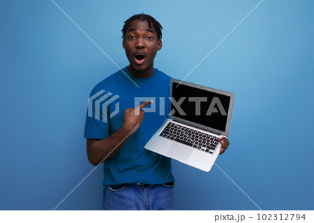 charismatic consultant demonstrates laptop screen on studio background with mockup and copy space 102312794