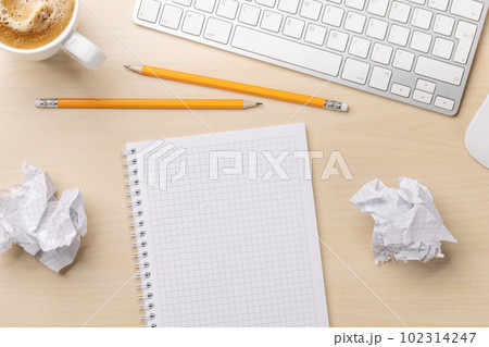 Top view of blank notepad, keyboard, coffee and crumpled papers 102314247