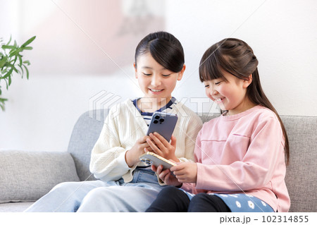 スマホを持つ小学生の女の子 102314855