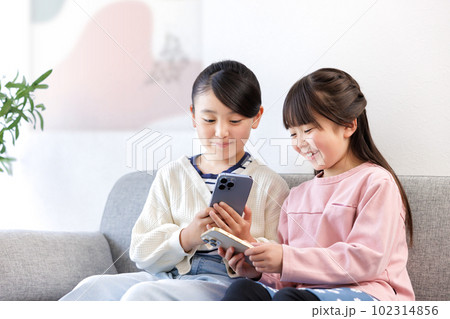 スマホを持つ小学生の女の子 スマホを持つ小学生の女の子 102314856