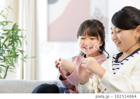 スマホを持つ小学生の女の子 102314864