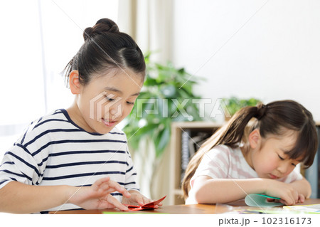 折り紙で遊ぶ小学生 102316173