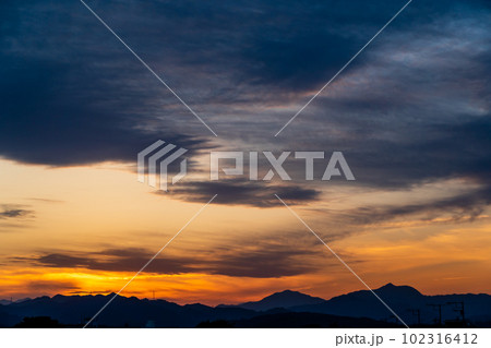 住宅街と山並みとオレンジに染まる夕焼 住宅街と山並みとオレンジに染まる夕焼 102316412