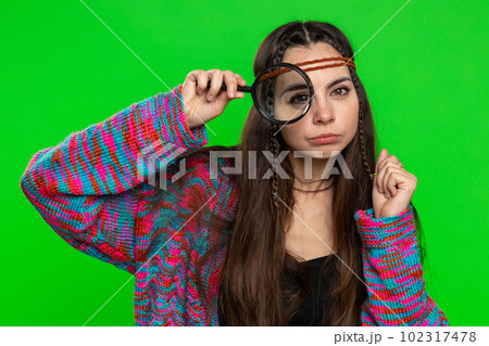 Investigator researcher woman with magnifying glass near face, looking into camera with big zoom eye Investigator researcher woman with magnifying glass near face, looking into camera with big zoom eye 102317478
