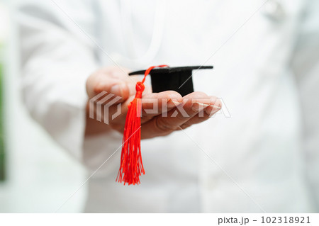 Asian woman doctor holding graduation hat in hospital, Medical education concept. 102318921