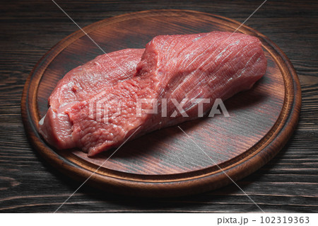 Fresh raw meat on dark cutting board 102319363