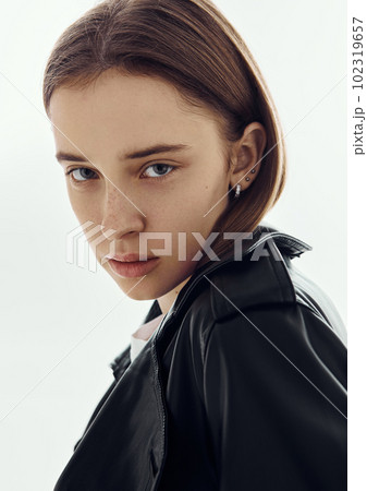 Portrait of beautiful young fashion model girl wearing leather jacket on white 102319657