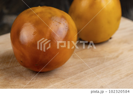 Old long - lying persimmon with dark spots Old long - lying persimmon with dark spots 102320584