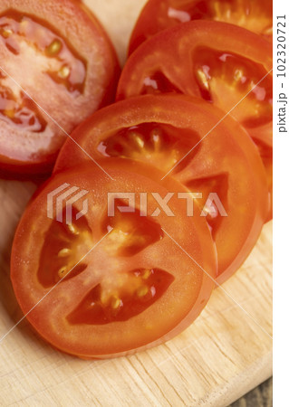 Sliced red fresh tomatoes on a board 102320721