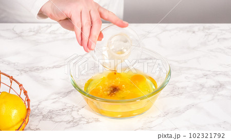 Step by step. Mixing ingredients in a glass mixing bowl to prepare lemon bundt cake. 102321792