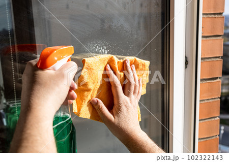 cleaning outdoor window glass with spray and rag 102322143