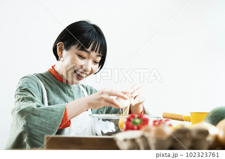 生卵を割る若い女性 102323761