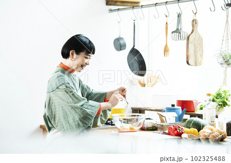 カボチャのパンケーキを作る若い女性 カボチャのパンケーキを作る若い女性 102325488