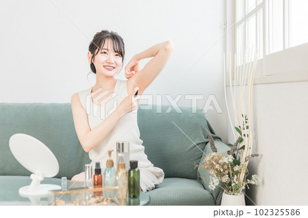 制汗剤スプレーを使う女性(脇・デオドラント) 制汗剤スプレーを使う女性(脇・デオドラント) 102325586