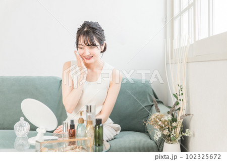 コットンで化粧水を肌につけるアジア人女性 102325672