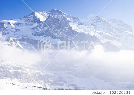 アルプス山脈、霧がかかった高山、霞が勝ったアルプスの山々、スイスアルプスの美しい雪山、雪山が続く山岳 102326231