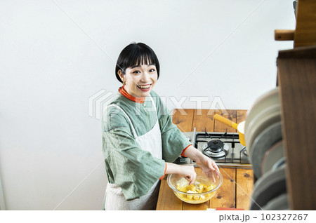 カボチャのパンケーキを作る若い女性 カボチャのパンケーキを作る若い女性 102327267