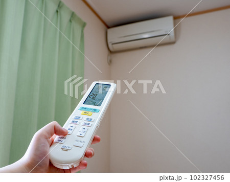 エアコンのリモコンで温度設定をする女性の手(設定28℃ 送風口閉) エアコンのリモコンで温度設定をする女性の手(設定28℃ 送風口閉) 102327456