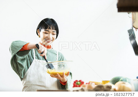 カボチャのパンケーキを作る若い女性 カボチャのパンケーキを作る若い女性 102327757