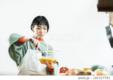 カボチャのパンケーキを作る若い女性 102327761