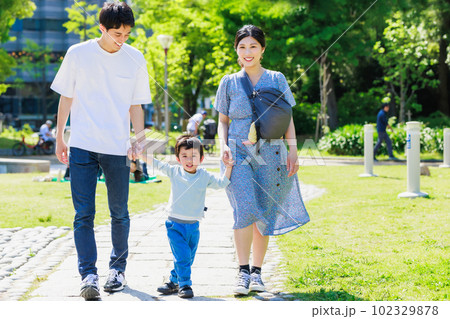 公園で手を繋いで散歩する家族の写真素材 [102329878] - PIXTA