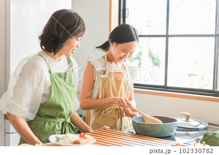 家のキッチンで子供と一緒に料理・クッキングする親子 家のキッチンで子供と一緒に料理・クッキングする親子 102330782