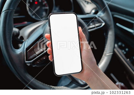 Woman sitting in a private car and hand holding smartphone mockup of blank screen. 102331263