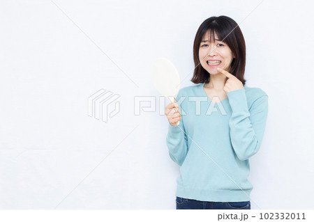 歯周病に悩む30代の女性 102332011