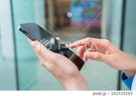Hands using smartphone in public areas, During leisure time. The concept of using the phone. 102333585