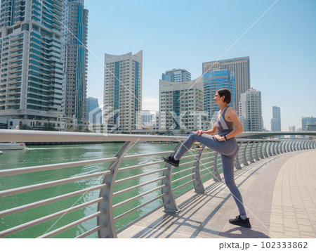 City Running - asian woman runner and Dubai marina skyline. City Running - asian woman runner and Dubai marina skyline. 102333862