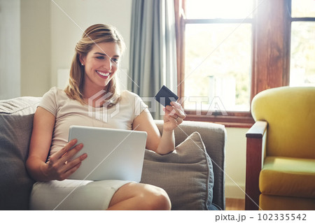 Getting in on the latest international trends without traveling. a young woman doing some online shopping on her digital tablet. Getting in on the latest international trends without traveling. a young woman doing some online shopping on her digital tablet. 102335542