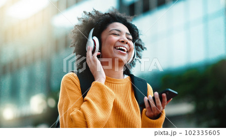 Headphones, phone and black woman in city dancing to music in outdoor lens flare for student lifestyle and wellness. Urban, gen z person dance and listening to audio tech on mobile app, 5g smartphone Headphones, phone and black woman in city dancing to music in outdoor lens flare for student lifestyle and wellness. Urban, gen z person dance and listening to audio tech on mobile app, 5g smartphone 102335605