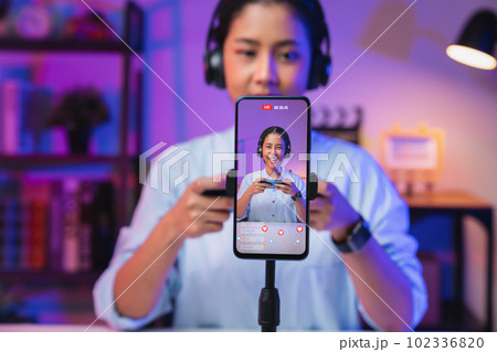 Vlogger live streaming podcast review, use microphones wear headphones with smartphone record video. Vlogger live streaming podcast review, use microphones wear headphones with smartphone record video. 102336820