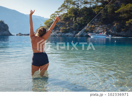 Cheerful woman enjoying the beach 102336971