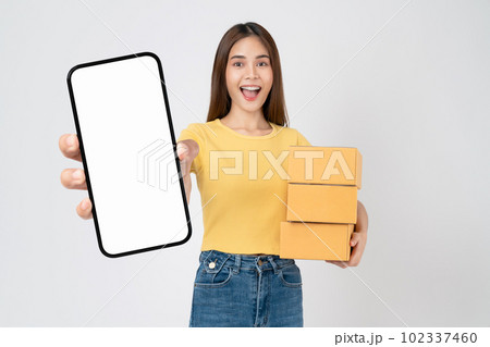 woman holding cardboard boxes and hands show smartphone mockup of blank screen on white background. 102337460