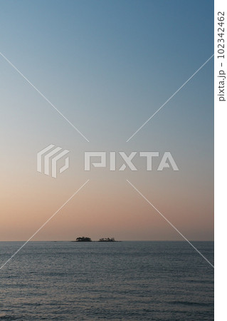 春霞の朝焼けに染まる富山湾と虻ガ島 102342462