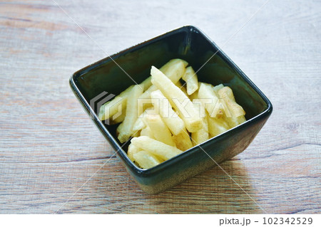 crispy snack French fries mixed with salt in cup on table crispy snack French fries mixed with salt in cup on table 102342529