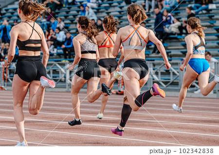rear view group female athlete runners running sprint race, summer athletics championships 102342838