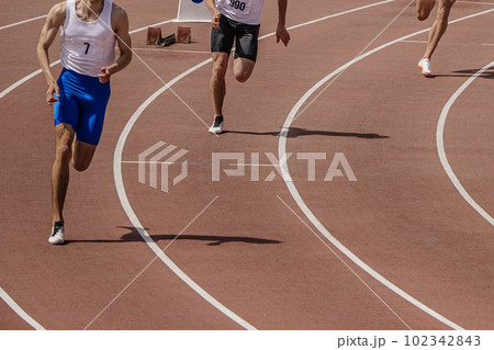 three male athlete runners starting running sprint race, summer athletics championships 102342843