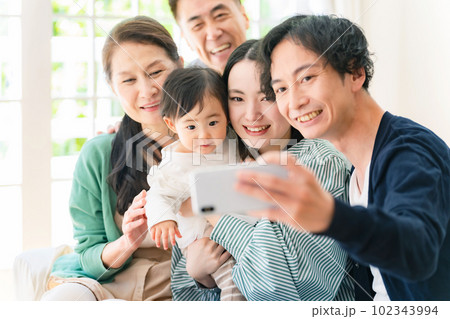 スマホで自撮りする赤ちゃんと家族 102343994
