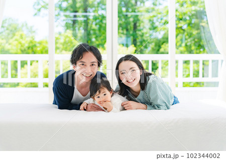 部屋でくつろぐ赤ちゃんと両親 102344002