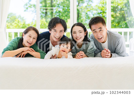 部屋でくつろぐ赤ちゃんと三世代家族 102344003