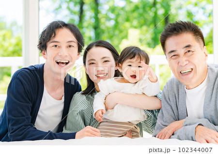 部屋でくつろぐ赤ちゃんと三世代家族 102344007