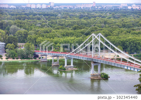 Pedestrian bridge over the Dnipro river in the summer city daytime landscape of Kyiv. 102345440