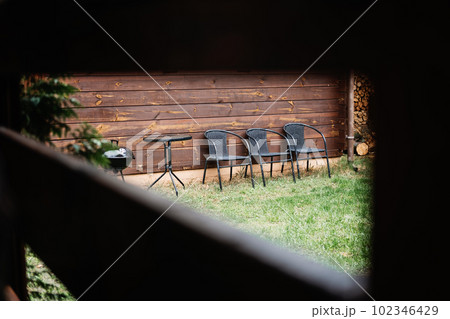 Vacation Home Grill and Chill with garden with BBQ. Vacation Home Rentals with Outdoor Grills. BBQ Family Picnic, Best BBQ Menu Ideas. Grill and chairs in the courtyard of country cottage Vacation Home Grill and Chill with garden with BBQ. Vacation Home Rentals with Outdoor Grills. BBQ Family Picnic, Best BBQ Menu Ideas. Grill and chairs in the courtyard of country cottage 102346429