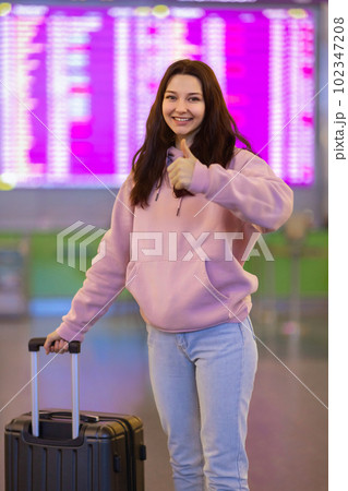 Happy Passenger Woman Thumbs Up in the Airport Hall, Travel Concept Happy Passenger Woman Thumbs Up in the Airport Hall, Travel Concept 102347208