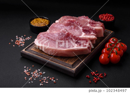 Raw pork on the bone or rib sliced with salt, spices and herbs Raw pork on the bone or rib sliced with salt, spices and herbs 102348497